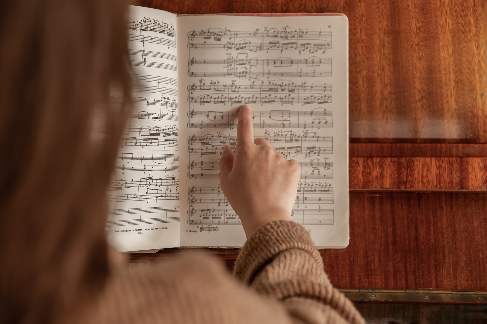 A woman shows her finger to the notes, the process of studying music.